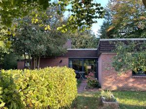 a brick house with a window and a yard at Stilvoller Bauhaus Bungalow mit Sauna in Lüneburger Heide für 8 Gäste in Wohlendorf