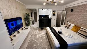 a bedroom with a large bed and a large television at Angely Studio-balcon & parcare gratuită ,Self Check-in in Onești