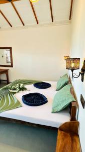 a white bed with two pillows on top of it at Surf Wave Hotel in Arugam Bay