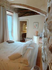a bedroom with a large bed and a stone wall at "Il Pollaio" guests house in Panicale