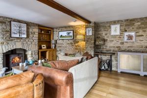 a living room with a couch and a fireplace at Old Stable Cottage in Kingham
