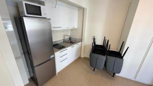 a small kitchen with a refrigerator and a microwave at Apartamentos Lin in Lloret de Mar +9 photos