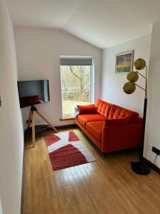 a living room with a red couch and a window at 1 Manse Lane in Portree