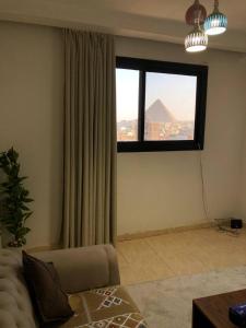 a living room with a window and a couch at Rafifi pyramids inn view in Cairo