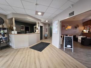 a lobby of a store with a counter and a chalkboard at Hotel Saint Odilon in Cluny