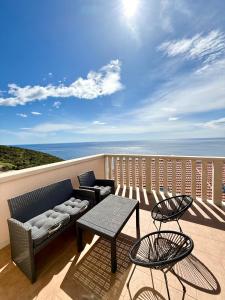 a balcony with a couch and two chairs and a table at Marojica Apartments 2 in Cavtat