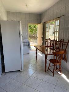 a kitchen with a table and chairs and a refrigerator at Refugio Paraiso in Arraial do Cabo