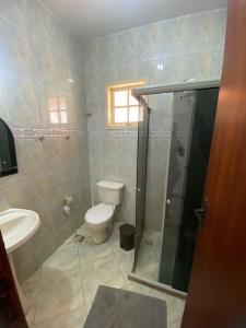 a bathroom with a toilet and a sink and a shower at Refugio Paraiso in Arraial do Cabo