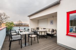 a patio with tables and chairs on a balcony at Kolonie Apartments in Žabovřesky
