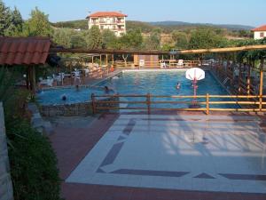 a swimming pool with people in the water at Athorama Hotel in Ouranoupoli