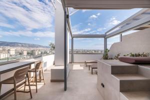a balcony with chairs and a view of the city at The HostMaster 910 Loft in Piraeus