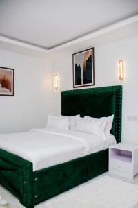 a bedroom with a large bed with a green headboard at Shanny's Cozy Studio in Eldoret