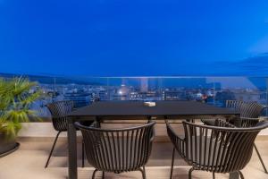 a table and chairs on a balcony with a blue screen at The HostMaster 910 Loft in Piraeus