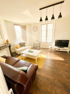 a living room with a couch and a table at Le Repos Poitevin Studio Atypique in Vivonne +12 photos