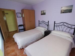 two beds in a room with purple walls at Casa Rural Javier in Valmuel
