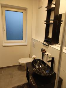 a bathroom with a sink and a toilet and a window at "Villa Barta am See" - Salzkammergut erleben in Traunkirchen +32 photos