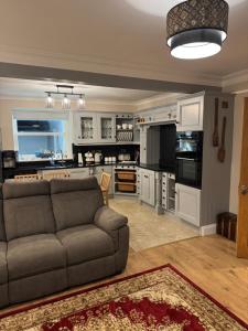 a living room with a couch and a kitchen at Charlie Óg's Bridge House in Dungloe
