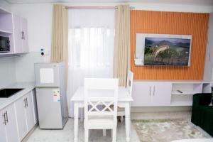 a kitchen with a white table and white cabinets at Shanny's Cozy Studio in Eldoret