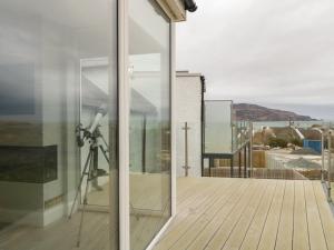 a glass door with a camera on a balcony at Portnablagh Cottage in Dunfanaghy