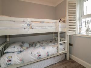 a bedroom with two bunk beds and a window at Portnablagh Cottage in Dunfanaghy