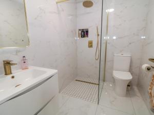 a white bathroom with a toilet and a sink at Portnablagh Cottage in Dunfanaghy +23 photos