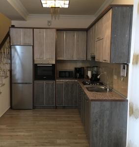 a kitchen with wooden cabinets and a stainless steel refrigerator at Deer Villa in Tsaghkadzor