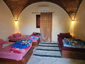 a room with three beds and a window at Badry Sahara Camp in Bawati