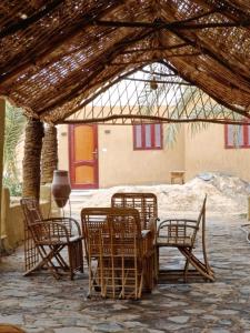 a group of chairs and tables under a pavilion at Badry Sahara Camp in Bawati