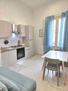Una pequeña cocina blanca con una mesa y sillas. en Appartamenti Silva Trapani, en Trapani