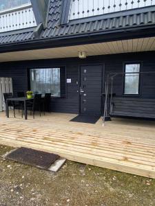 a wooden deck with a table and a house at Lomayksiö Vääksy 34m2 in Vääksy