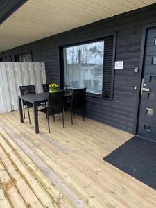 a patio with a table and chairs on a deck at Lomayksiö Vääksy 34m2 in Vääksy +6 photos