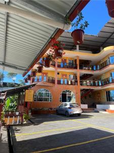 a car parked in a parking lot in front of a building at Hotel Los Bancos in San Miguel de los Bancos