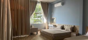 a bedroom with a bed and a window at Vung Tau Villa mini sát biển - Gitico Homestay in Vung Tau