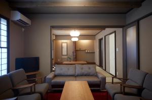 a living room with a couch and a tv at 一棟宿 倉持 in Kusatsu