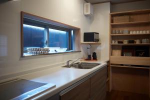 a kitchen with a sink and a window at 一棟宿 倉持 in Kusatsu