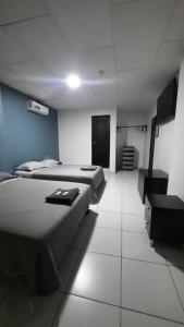 a room with two beds and a television in it at Hotel confort in Guayaquil +3 photos