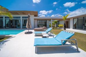 a patio with two blue lounge chairs and a pool at Ming Resort Phuket in Mai Khao Beach +53 photos