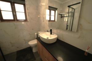 a white bathroom with a sink and a toilet at Casa Ti Madalena in Arganil +15 photos