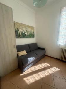 a couch in a room with a painting on the wall at Appartamento Centrale - sulla pedonale in Dolceacqua