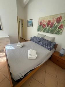 a bedroom with a bed with a painting on the wall at Appartamento Centrale - sulla pedonale in Dolceacqua