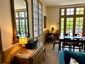 a dining room with a table and chairs and windows at Maison d'hôtes Villa Meinga in Saint-Coulomb