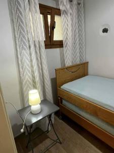 a bedroom with a bed and a table with a lamp at Sunrise View in Kardámyla