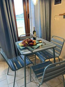 a table with a plate of fruit and a bottle of wine at Sunrise View in Kardámyla