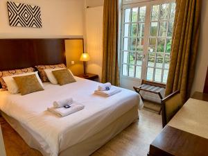 a bedroom with a large bed with towels on it at Maison d'hôtes Villa Meinga in Saint-Coulomb