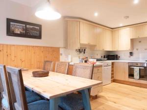 a kitchen with a wooden table and some chairs at Steading Cottage - Ukc5957 in Port Appin