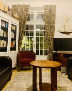 a living room with a table and a tv at Maison d'hôtes Villa Meinga in Saint-Coulomb