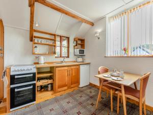 a kitchen with a wooden table and a table and chairs at Hayloft - E3759 in Berrynarbor +11 photos