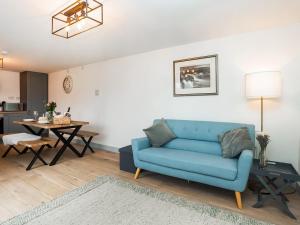 a living room with a blue couch and a table at Pencefn Cottage in Llanddeiniolen +22 photos