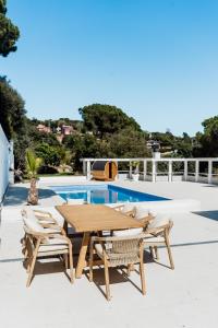 a wooden table and chairs next to a swimming pool at Casa Blanca in Dosríus