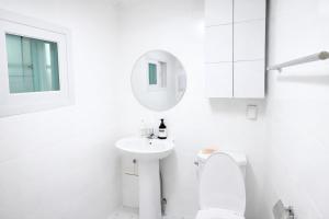 a white bathroom with a toilet and a sink at MAMA Alice in Seoul +54 photos